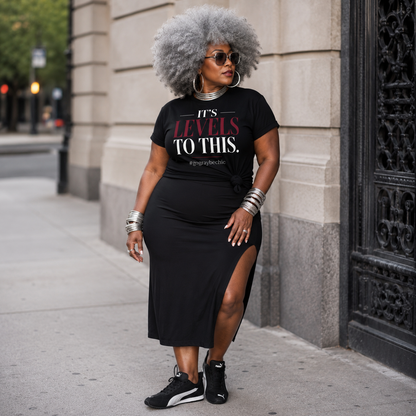 Woman wearing a black t-shirt with text and a black skirt on a city street.